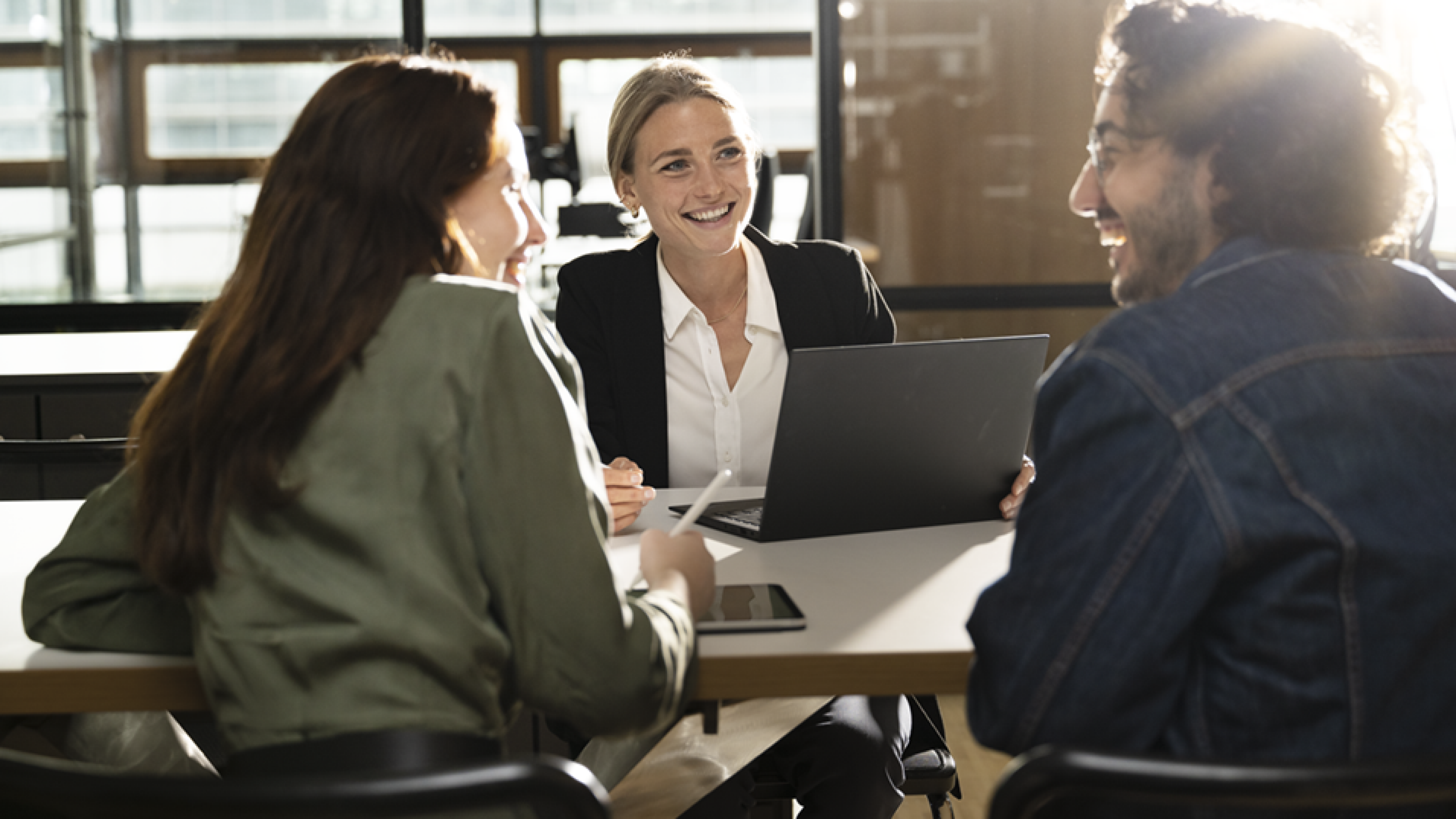 People are sitting at a table, laughing and collaboration.